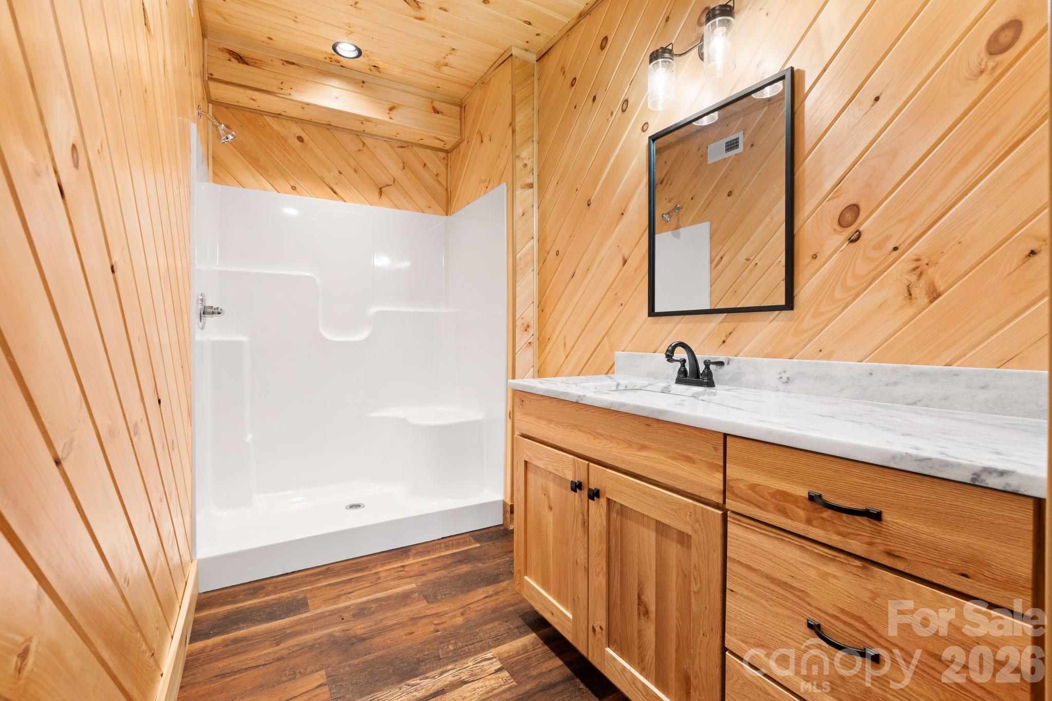 449 Hampton Ridge Road Fleetwood, NC 28626 - Photo 10 of 48 a bathroom with a sink a mirror and a shower