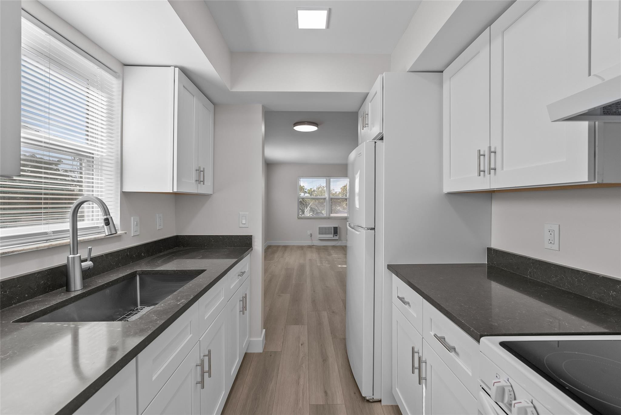 a kitchen with granite countertop a sink and cabinets