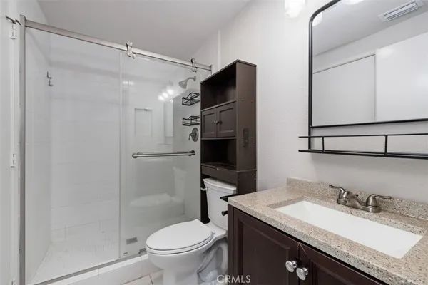 a bathroom with a granite countertop sink toilet and shower