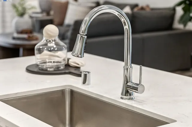 a kitchen with stainless steel appliances kitchen island granite countertop a stove a sink a refrigerator and a dining table with wooden floor