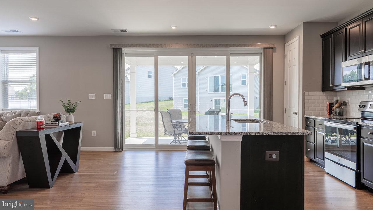 12610 Rosencrans Dr. Hagerstown, MD 21740 - Photo 6 of 49 a kitchen with stainless steel appliances granite countertop a stove a sink dishwasher and a dining table with wooden floor