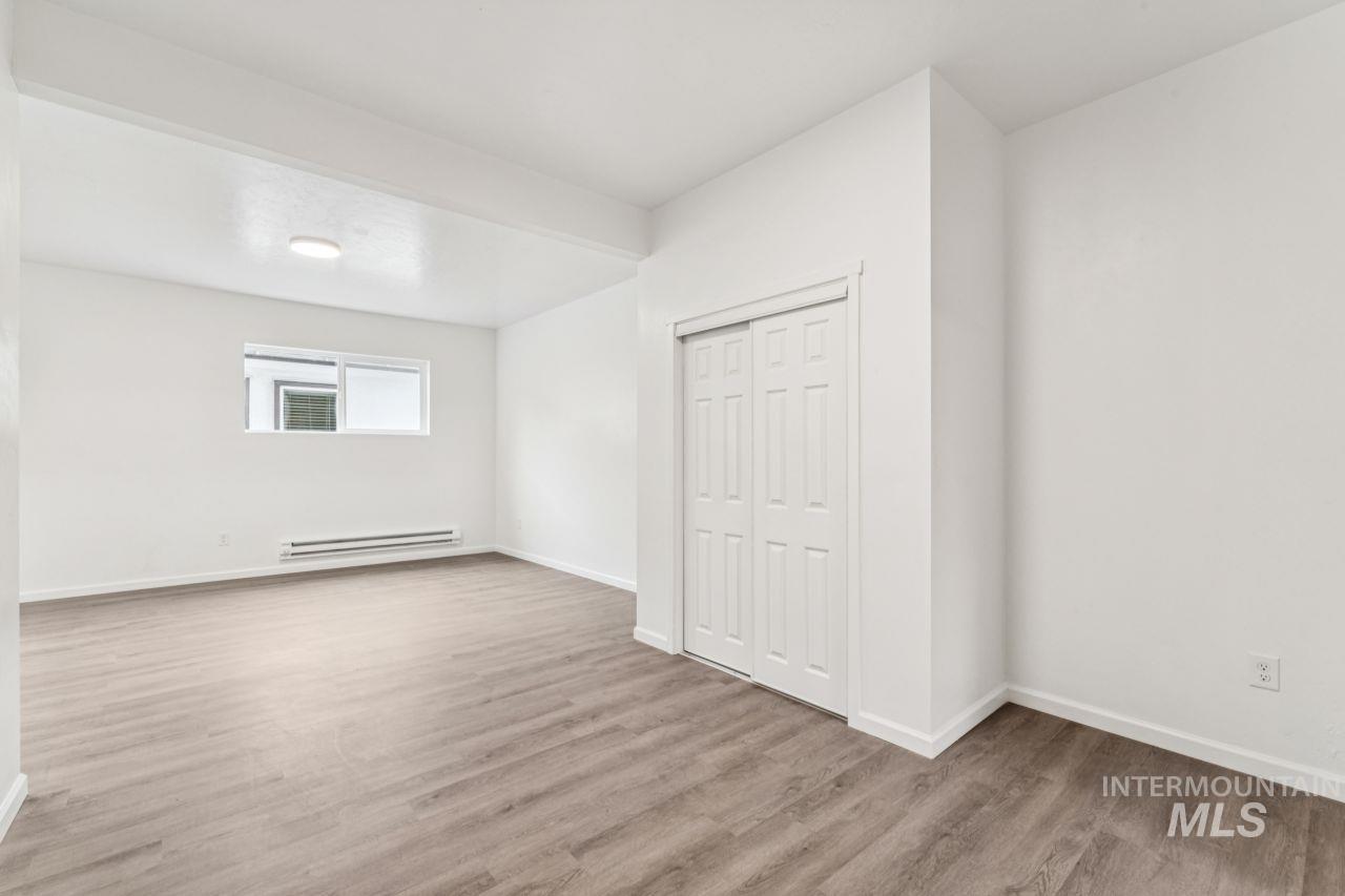 911 2nd Street South Nampa, ID 83651 - Photo 12 of 50 Unfurnished bedroom featuring light wood finished floors, a closet, and baseboard heating
