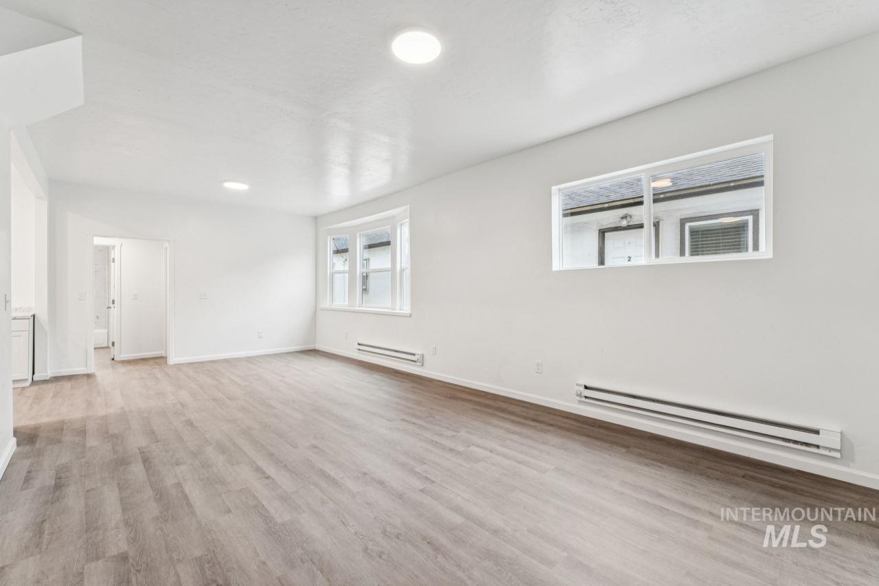 911 2nd Street South Nampa, ID 83651 - Photo 13 of 50 Empty room with baseboard heating and light wood-style floors