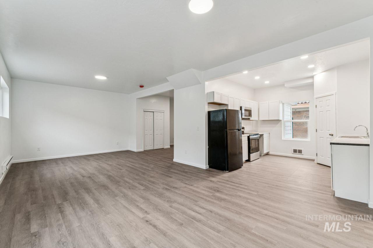 911 2nd Street South Nampa, ID 83651 - Photo 50 of 50 Kitchen with appliances with stainless steel finishes, open floor plan, white cabinets, light countertops, and light wood finished floors