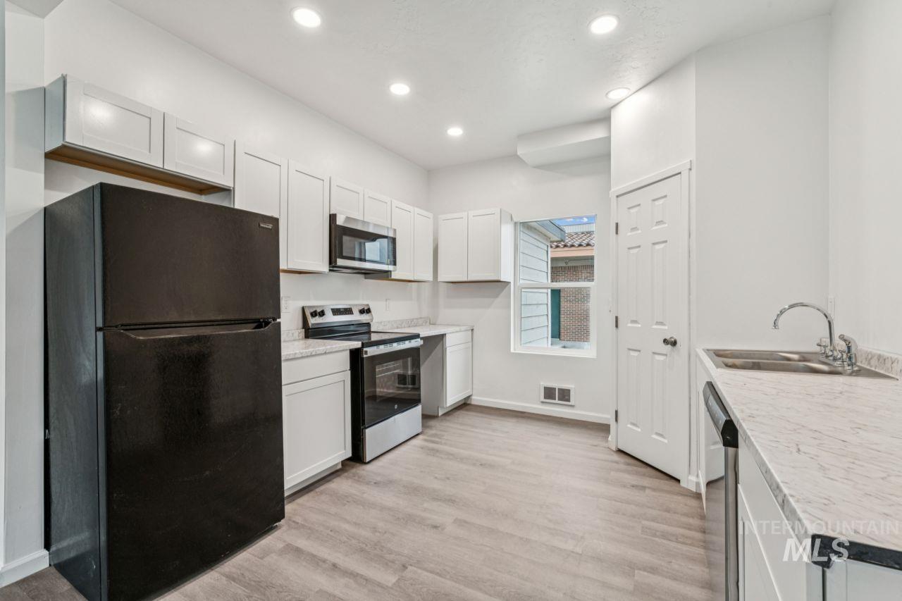 911 2nd Street South Nampa, ID 83651 - Photo 14 of 50 Kitchen with stainless steel appliances, light countertops, white cabinetry, light wood-type flooring, and recessed lighting