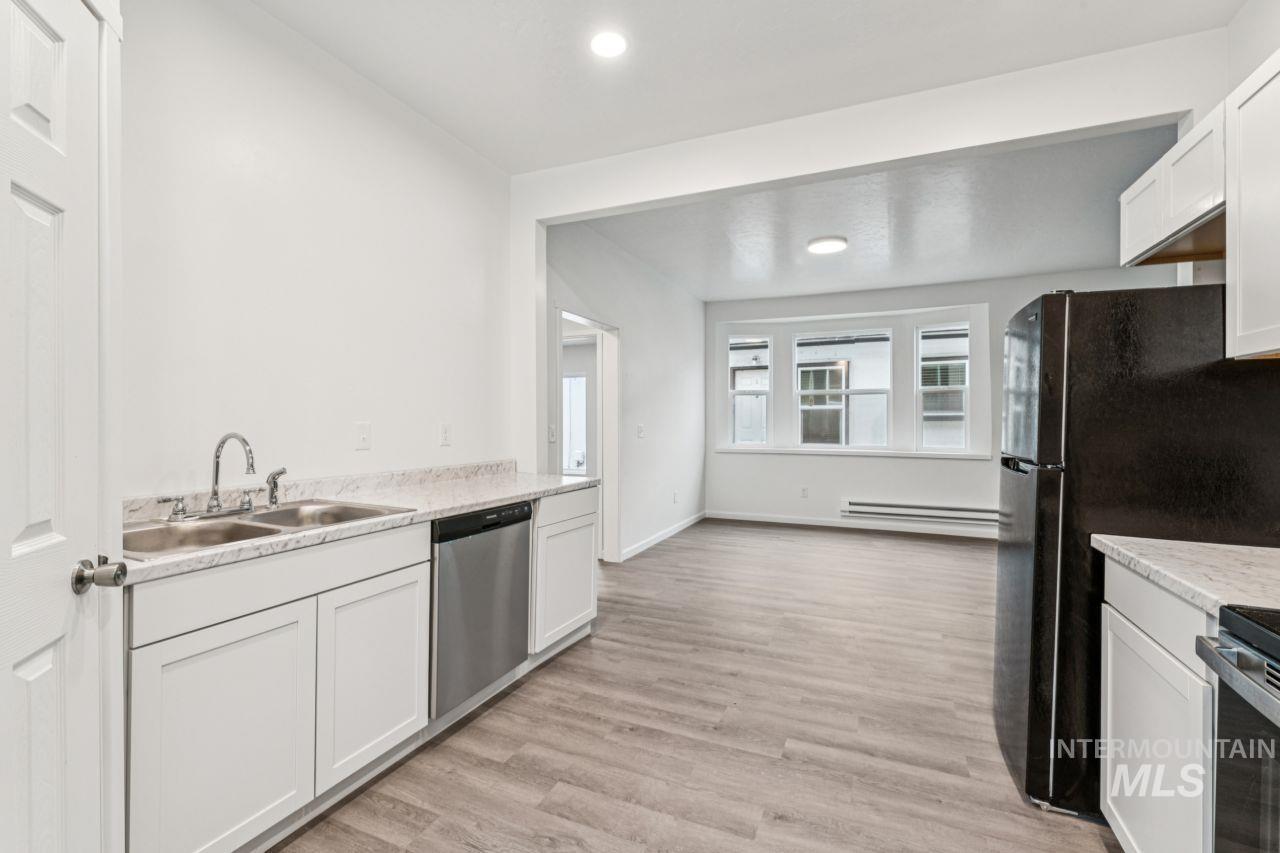911 2nd Street South Nampa, ID 83651 - Photo 15 of 50 Kitchen featuring white cabinetry, light wood-type flooring, dishwasher, recessed lighting, and baseboard heating