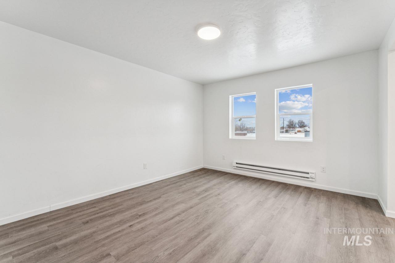 911 2nd Street South Nampa, ID 83651 - Photo 23 of 50 Spare room featuring a baseboard heating unit and light wood finished floors