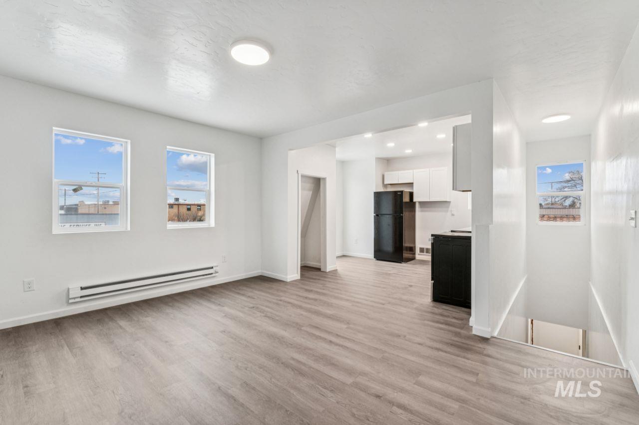 911 2nd Street South Nampa, ID 83651 - Photo 24 of 50 Unfurnished living room featuring a baseboard radiator, light wood-style flooring, and healthy amount of natural light