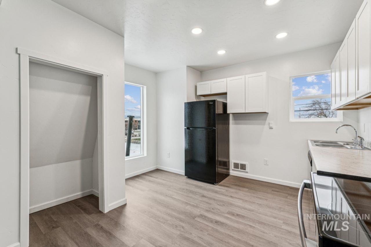 911 2nd Street South Nampa, ID 83651 - Photo 25 of 50 Kitchen featuring white cabinets, black appliances, light wood-type flooring, healthy amount of natural light, and recessed lighting