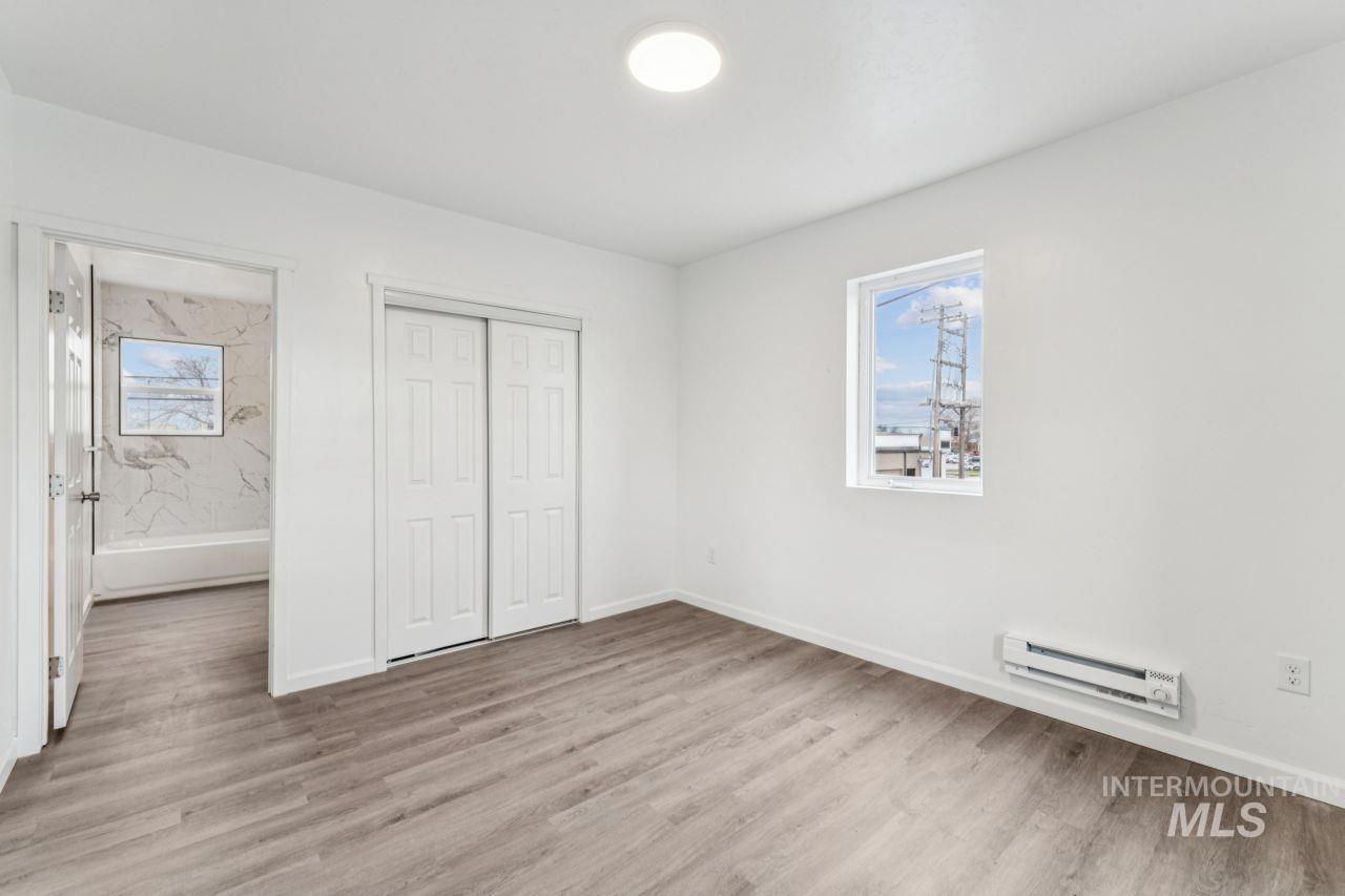 911 2nd Street South Nampa, ID 83651 - Photo 29 of 50 Unfurnished bedroom featuring a baseboard radiator, light wood-style floors, and a closet