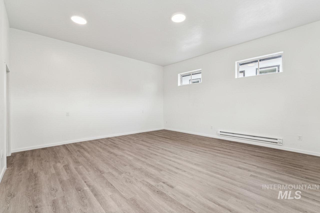 911 2nd Street South Nampa, ID 83651 - Photo 4 of 50 Unfurnished room featuring light wood-type flooring, a baseboard heating unit, and recessed lighting