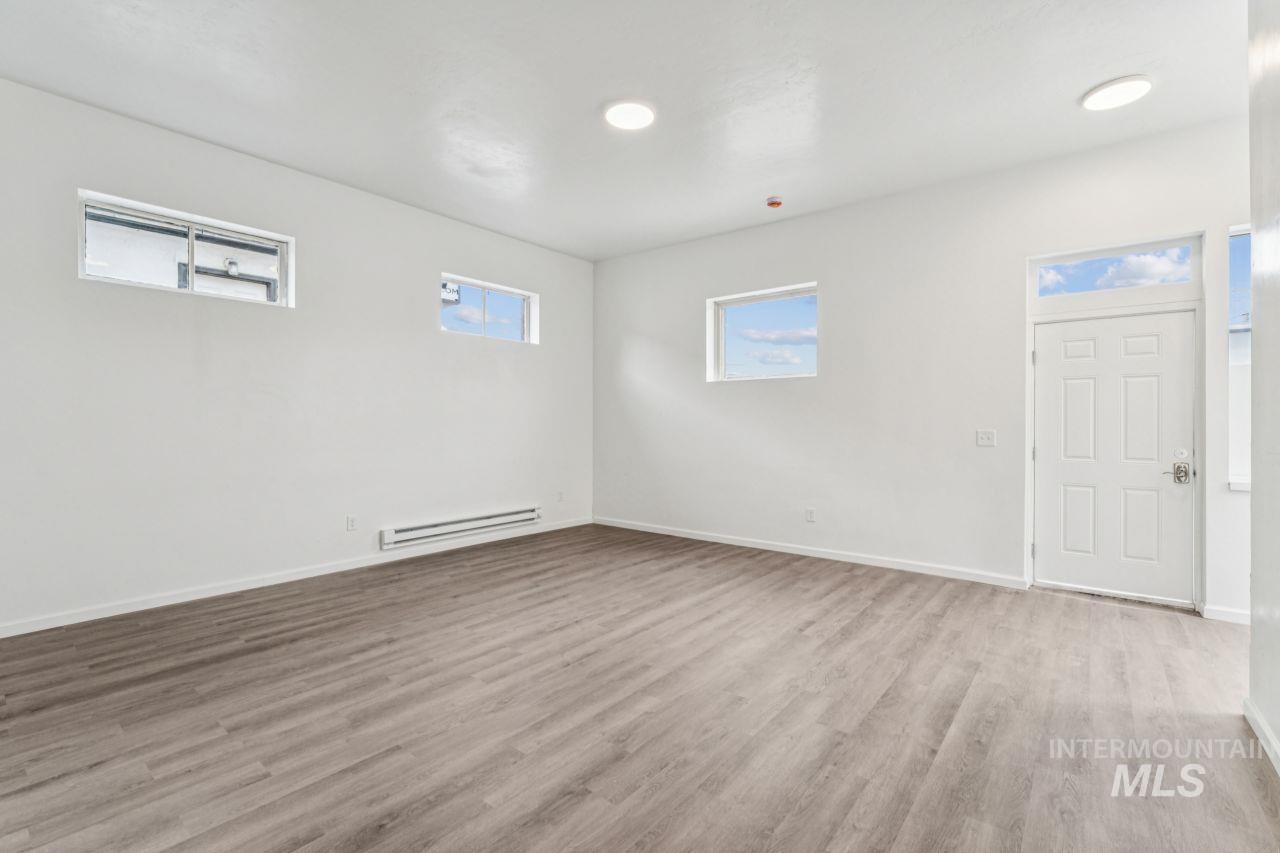 911 2nd Street South Nampa, ID 83651 - Photo 6 of 50 Empty room with light wood-style flooring and a baseboard heating unit