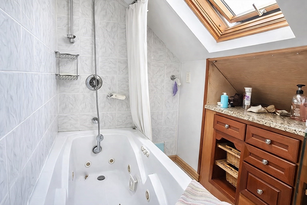 53 Hillside Street, Unit 1 Boston, MA 02120 - Photo 8 of 10 a bathroom with a tub sink and mirror