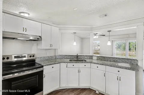 a kitchen with stainless steel appliances granite countertop a sink stove and cabinets