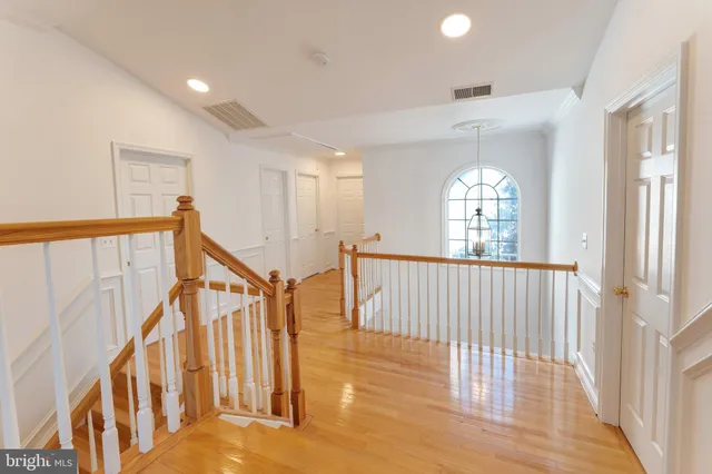a view of a hallway with wooden floor and stairs