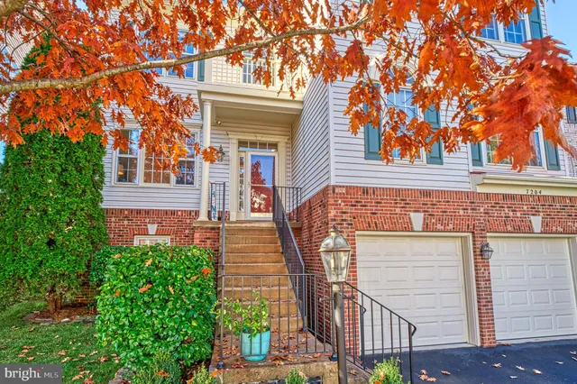 a view of a house with a small yard and potted plants