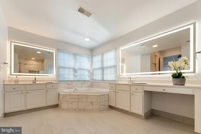 a bathroom with a bathtub sink and mirror