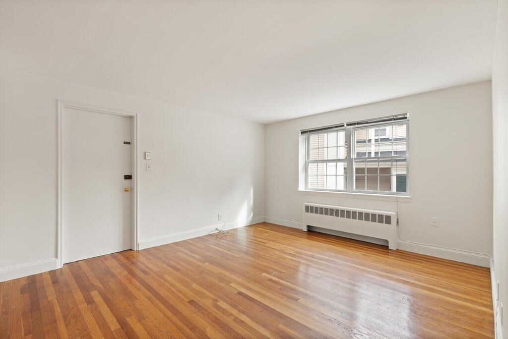 4 Menotomy Road, Unit 5 Arlington, MA 02476 - Photo 5 of 13 a view of an empty room with wooden floor and a window