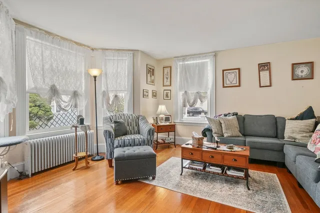 a living room with furniture wooden floor and a large window