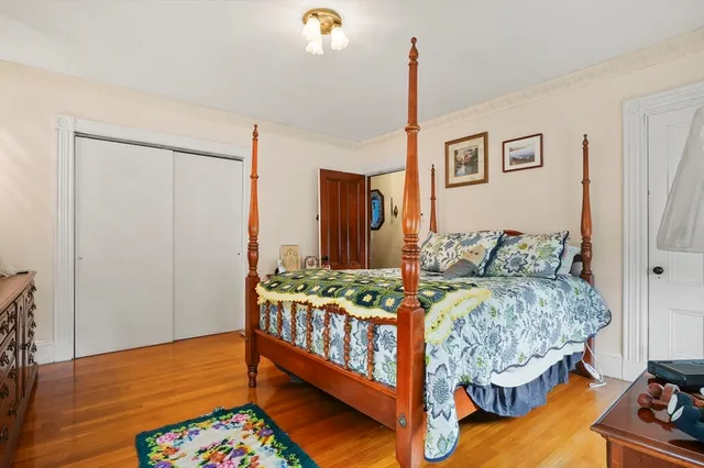 a bedroom with a bed and dresser with mirror