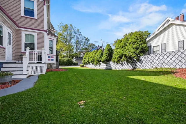 a front view of a house with a garden and trees