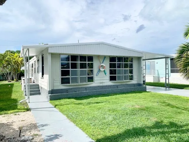 a view of a house with a yard and sitting area