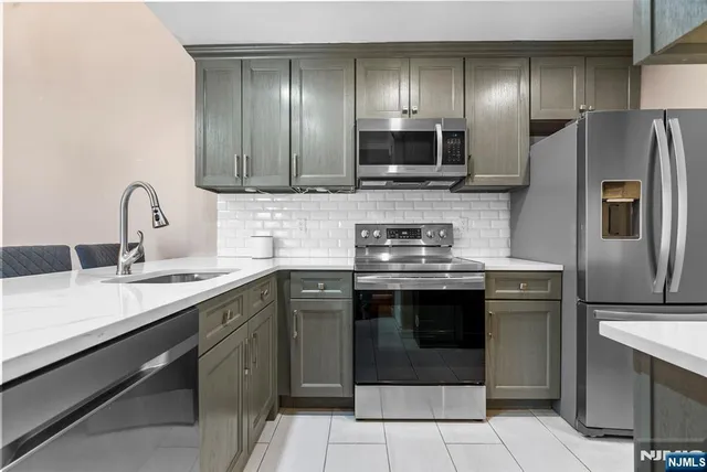 a kitchen with stainless steel appliances a refrigerator stove and microwave