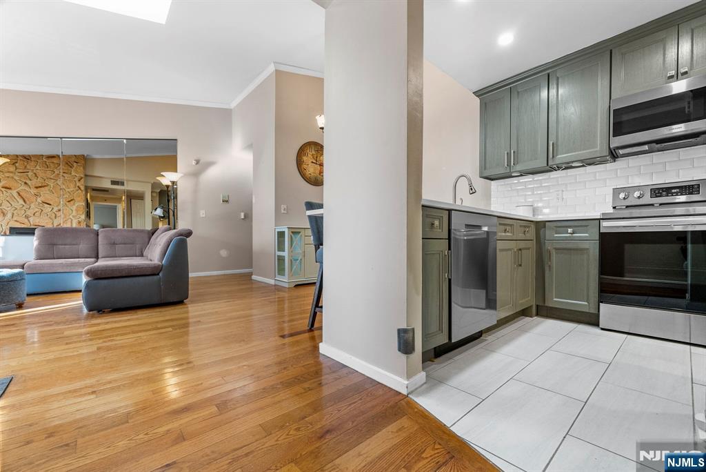 753 Summer, Unit 3D Newark, NJ 07104 - Photo 15 of 41 a kitchen with stainless steel appliances granite countertop a stove a sink and a refrigerator