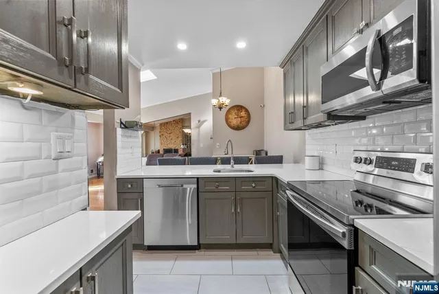 a kitchen with stainless steel appliances granite countertop a refrigerator and a stove