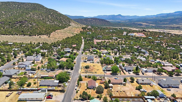 132 Rex Layne Drive Central, UT 84722 - Photo 38 of 39 Aerial panorama showcasing a residential community nestled against a tree-covered hillside, with distant mountains forming a natural backdrop