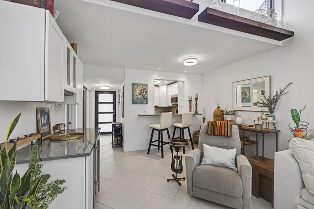 a living room with furniture and a dining table with kitchen view