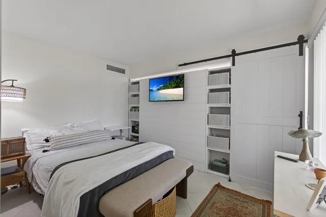 a bedroom with a bed and a flat screen tv