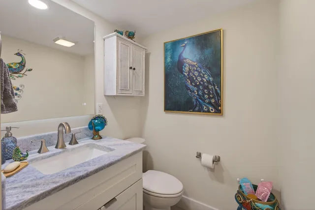 a bathroom with a granite countertop sink a vanity and a toilet