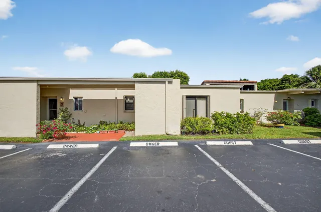 a front view of a house with a yard and potted plants