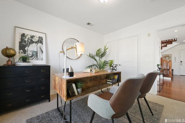 a view of a workspace room with furniture and a potted plant