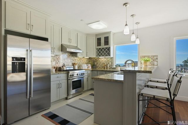 a kitchen with a sink a counter space appliances and cabinets