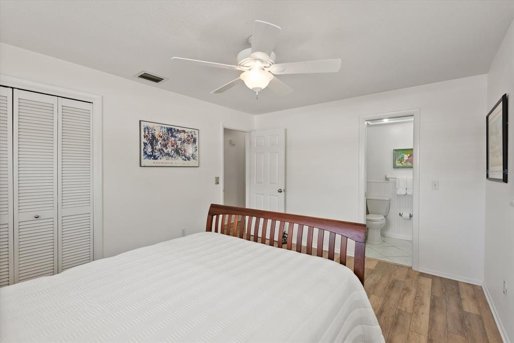 1700 Patricia Avenue Dunedin, FL 34698 - Photo 18 of 31 a bedroom with a large bed and a chandelier