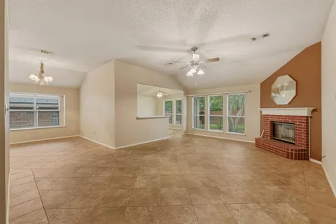 a view of an empty room with a fireplace and a window
