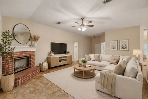 a living room with furniture a fireplace and a flat screen tv