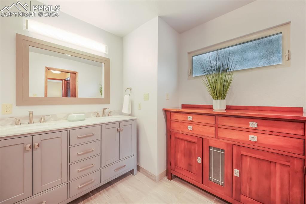18585 Augusta Drive Monument, CO 80132 - Photo 37 of 50 a bathroom with a double vanity sink and a mirror