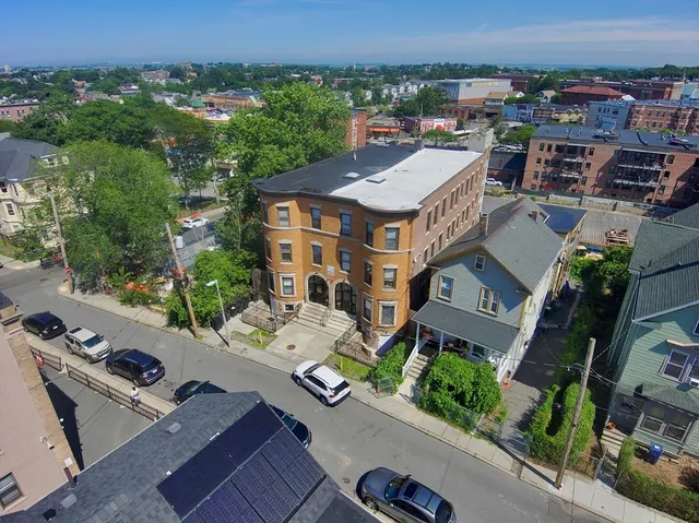 an aerial view of a house with a yard patio and outdoor seating