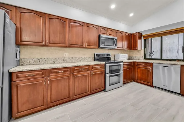 a kitchen with stainless steel appliances granite countertop a stove sink and cabinets