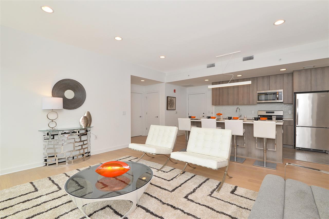 600 Harrison Street, Unit 603 Hoboken, NJ 07030 - Photo 5 of 15 a living room with furniture and kitchen view