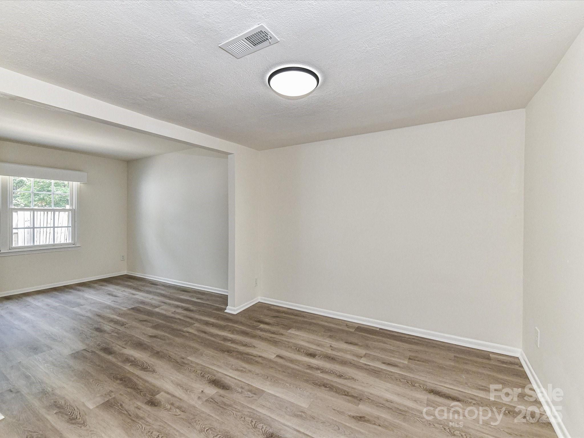 8060 Knights Bridge Road Charlotte, NC 28210 - Photo 12 of 33 an empty room with wooden floor and windows