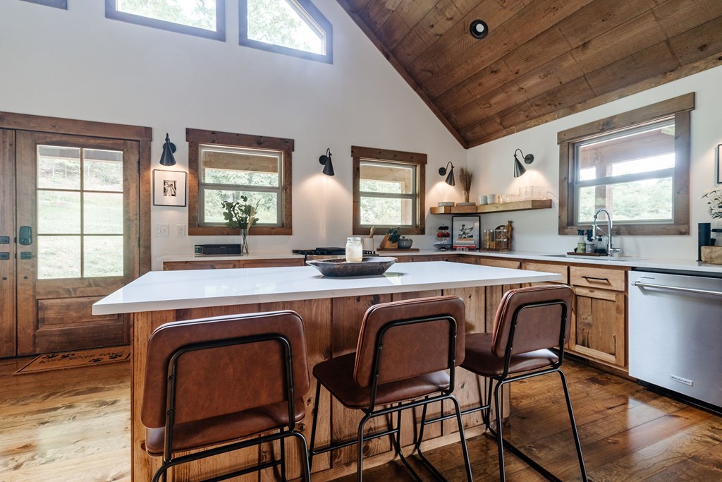 89 High Mdws Drive Morganton, GA 30560 - Photo 22 of 63 a dining hall with stainless steel appliances granite countertop a stove a sink dishwasher and chairs with wooden floor
