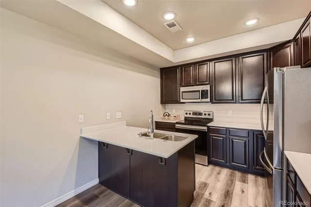 a kitchen with kitchen island a sink stove and refrigerator