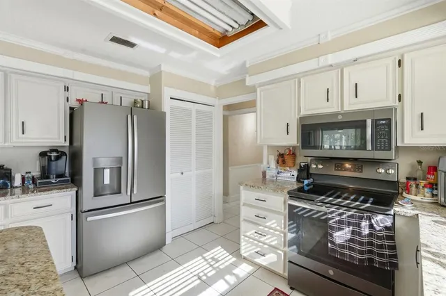 a kitchen with stainless steel appliances granite countertop a refrigerator stove and sink