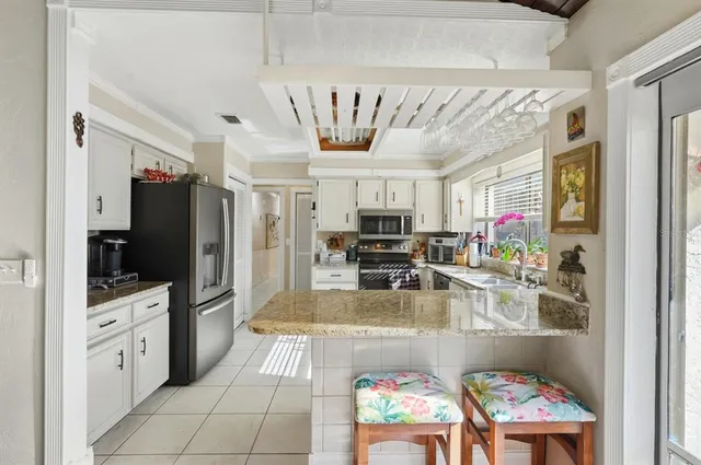 a kitchen with kitchen island granite countertop a sink appliances and cabinets