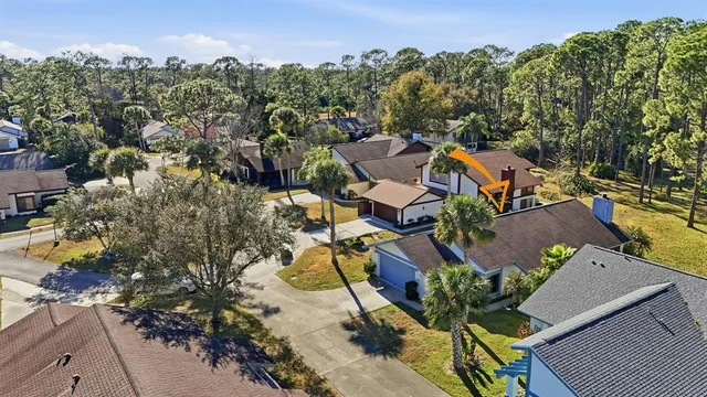 an aerial view of residential houses with outdoor space and trees all around