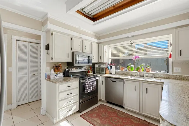 a kitchen with stainless steel appliances granite countertop a stove sink and cabinets